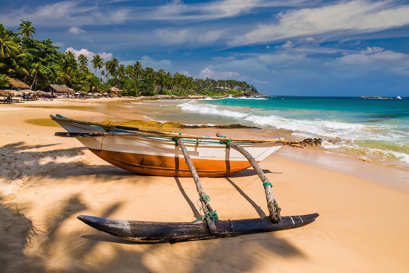 Untouched tropical beach with palms and fishing boats in Sri-Lanka